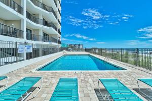 a swimming pool with blue lounge chairs next to a building at Direct Ocean Front 3BR 3BA Beach Front in Myrtle Beach