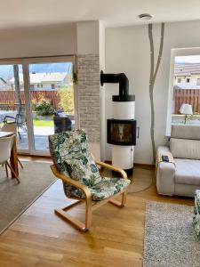 a living room with a chair and a fireplace at Family house in Bled region in Radovljica