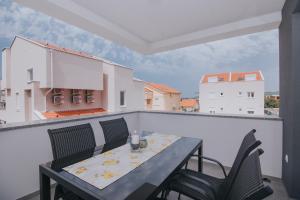 a table and chairs on a balcony with a view at Relax Apartments in Novalja +28 photos
