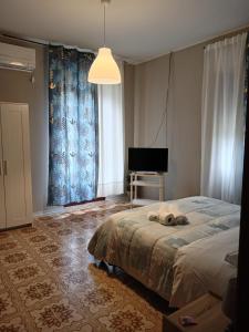 um quarto com uma cama e uma televisão em VILLA ESMERALDA em Pozzilli