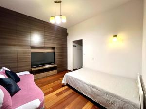 Un dormitorio con una cama y un televisor de pantalla plana. en K22 Filtrowa Apart Warsaw, en Varsovia