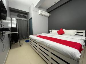 グワーハーティーにあるUrban Inn Rukminigaonのベッドルーム1室(赤毛布付きの大型ベッド1台付)