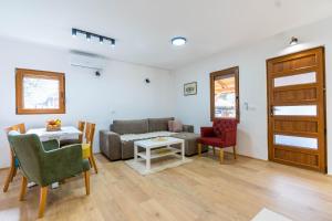 ein Wohnzimmer mit einem Sofa, einem Tisch und Stühlen in der Unterkunft Apartmani Vajati Gradac in Valjevo
