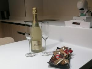 a bottle of wine and two wine glasses on a counter at Asturin House - PARKING GRATIS in Salamanca