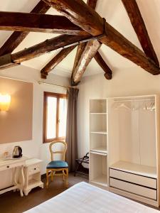 a bedroom with a bed and a desk and a chair at Alla Corte Rossa in Venice