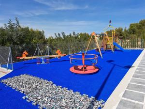une aire de jeux vide avec un sol bleu et des balançoires dans l'établissement Lovely 6-Bed Villa in Orihuela costa, à Orihuela