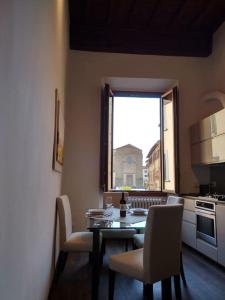 uma sala de jantar com uma mesa e cadeiras e uma janela em Wonderful View Carmine em Florença