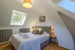 een slaapkamer met een bed met witte lakens en een raam bij Ker Anna - Maison proche plage pour 8 in Sarzeau