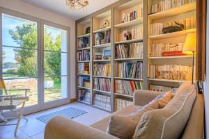 een woonkamer met een grote boekenplank gevuld met boeken bij Ker Anna - Maison proche plage pour 8 in Sarzeau