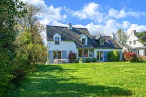 een wit huis met een tuin met groen gras bij Ker Anna - Maison proche plage pour 8 in Sarzeau