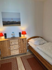 ein Schlafzimmer mit einem Bett und einer Kommode mit zwei Lampen in der Unterkunft " Steilküstenblick" FP, L-10-7 in Heiligenhafen