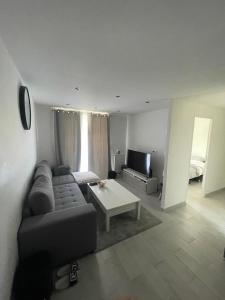 a living room with a couch and a table at Appartement 2 pièces in Nice