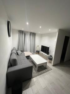 a living room with a couch and a table at Appartement 2 pièces in Nice