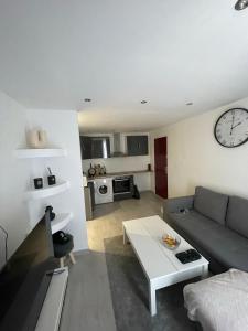 a living room with a couch and a clock on the wall at Appartement 2 pièces in Nice