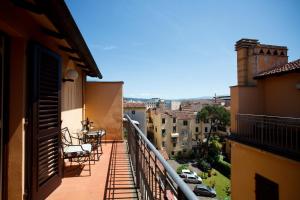 a balcony with chairs and a table on a building at Hotel Albani Firenze in Florence