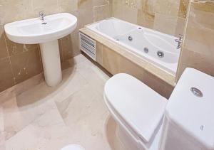 ein Badezimmer mit einem Waschbecken, einem WC und einer Badewanne in der Unterkunft Apartamento con terraza en primera línea de playa by ISA Hoteles in Estepona