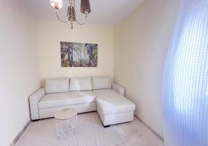 ein Wohnzimmer mit einem weißen Sofa und einem Tisch in der Unterkunft Apartamento con terraza en primera línea de playa by ISA Hoteles in Estepona