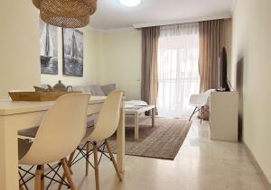 eine Küche und ein Wohnzimmer mit einem Tisch und Stühlen in der Unterkunft Apartamento con terraza en primera línea de playa by ISA Hoteles in Estepona