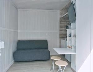 a small living room with a couch and two stools at MINI estudio El Reloj in San Nicolás