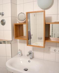ein Bad mit einem Waschbecken und einem Spiegel in der Unterkunft Haus Schwedes in Titisee-Neustadt