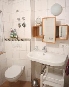 a white bathroom with a toilet and a sink at Haus Schwedes in Titisee-Neustadt
