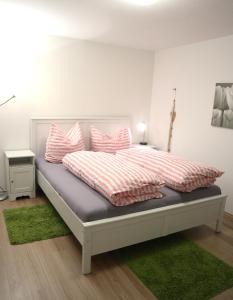 a bedroom with a bed with pink and white pillows at Haus Schwedes in Titisee-Neustadt