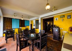 uma sala de jantar com paredes amarelas e uma mesa e cadeiras em Bloom Boutique Waterfront Fort Kochi em Cochin