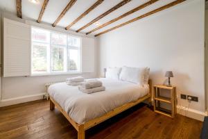 - une chambre avec un lit et des serviettes dans l'établissement Historic 18th Century Terrace House, à Londres
