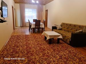 a living room with a couch and a table at Rose House in Sheki