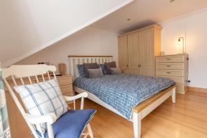 a bedroom with a bed and a dresser and a chair at Dudley House in Woolacombe
