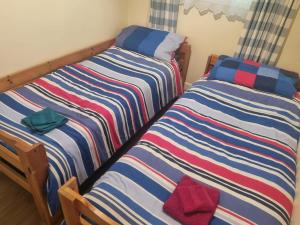 キャメルフォードにあるBeautiful 2-Bed Villa in Camelfordのベッド2台が隣同士に設置された部屋です。