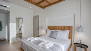 a bedroom with a bed with two towels on it at Kalami Suites in Livadi