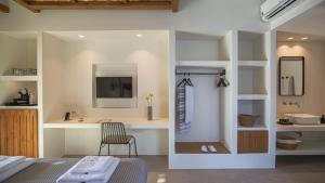a bathroom with a sink and a desk with a chair at Kalami Suites in Livadi