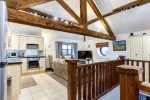 a kitchen and living room with a wooden railing at The Saddlery Cheshire in Congleton