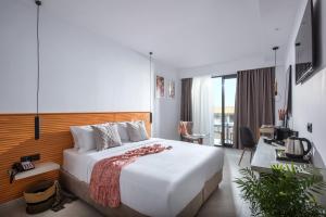 una camera d'albergo con un grande letto e una scrivania di Meramaglia Hotel a Mália
