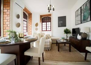uma sala de estar com uma mesa e uma sala de estar com um sofá em Palacete da Serenata @ Sé Velha em Coimbra