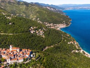 uma vista aérea de uma cidade numa colina junto ao oceano em Bed and Breakfast Rooms Sandalj em Mošćenička Draga