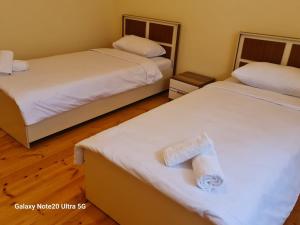 Dos camas en una habitación de hotel con toallas. en Rose House, en Sheki