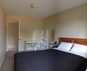 een slaapkamer met een bed en een tafel en stoelen bij Highland Place Avonhead in Christchurch