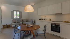 a kitchen and living room with a table and chairs at Kalami Suites in Livadi