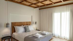 a bedroom with a bed with two towels on it at Kalami Suites in Livadi