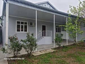une maison avec des murs blancs et une terrasse couverte dans l'établissement Rose House, à Shaki