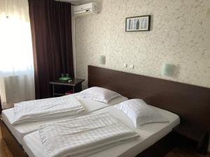 a bedroom with two white pillows on a bed at Pension La Ponton in Eşelniţa