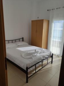 a bedroom with a bed and a cabinet and a window at IONIAN PEARL in Borsh
