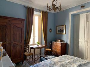 um quarto com uma cama, uma secretária e uma mesa em La Maison du Magistrat em Durban-Corbières