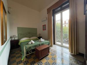 ein Schlafzimmer mit einem grünen Bett und einem großen Fenster in der Unterkunft Teatro del Sole Cavour in Palermo