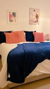 a bedroom with a bed with blue sheets and pillows at Sea views Family & Relocators by O & J Properties in Shoreham-by-Sea