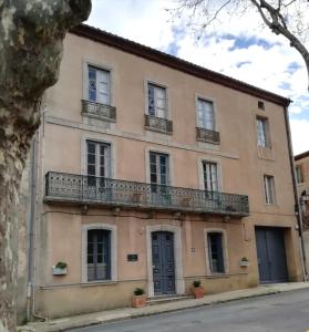 an old building with a balcony on a street at La Maison du Magistrat in Durban-Corbières