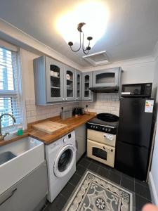 a kitchen with a black refrigerator and a dishwasher at Sea views Family & Relocators by O & J Properties in Shoreham-by-Sea