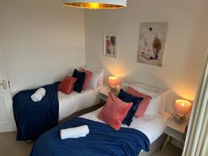 two beds in a room with two lamps on tables at Sea views Family & Relocators by O & J Properties in Shoreham-by-Sea